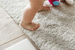 a little baby standing on a carpet